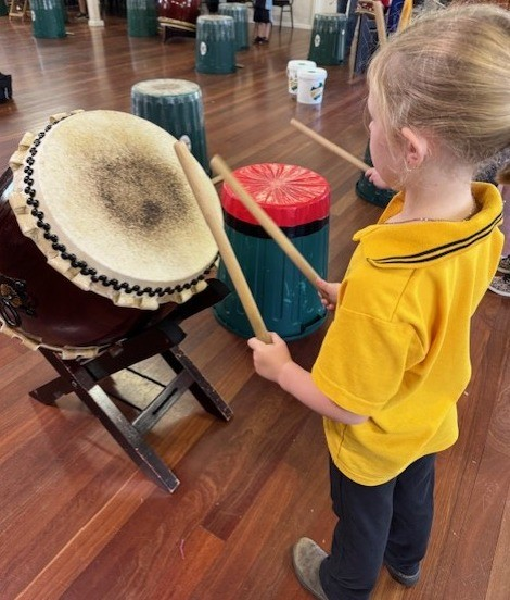 A student playing a drum